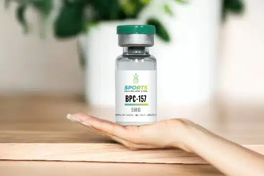 Research-grade BPC-157 peptide vial displayed on palm against wooden surface with green foliage background